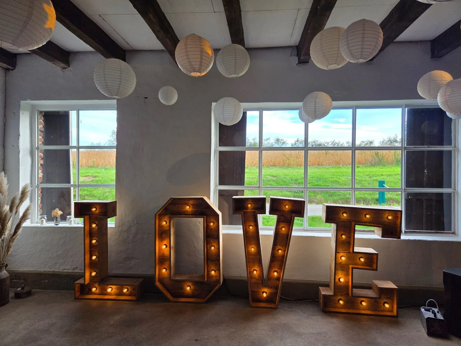 Vintage-LOVE frontal vor Sprossenfenstern, beleuchtet