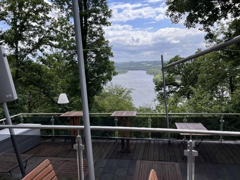 Blick von der Glas-Terrasse des Jagdhaus Schellenberg durch Bäume auf den Baldeneysee mit Segelbooten